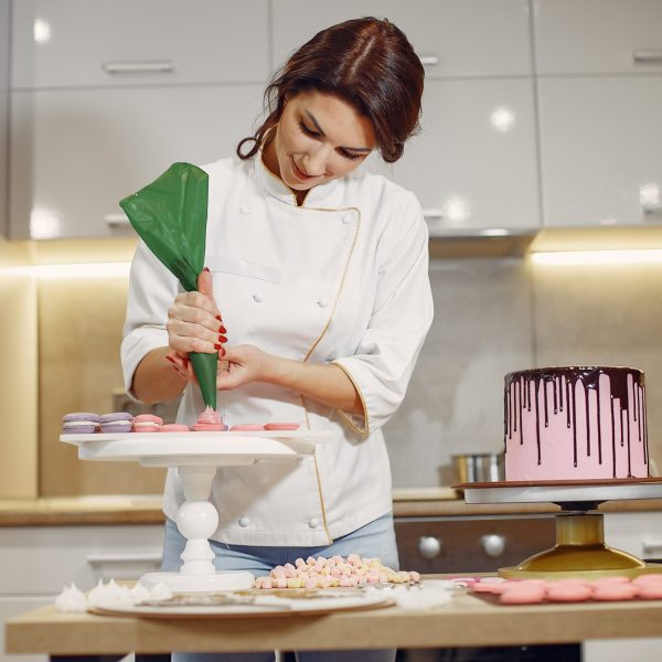 confectioner-uniform-decorates-cake-min